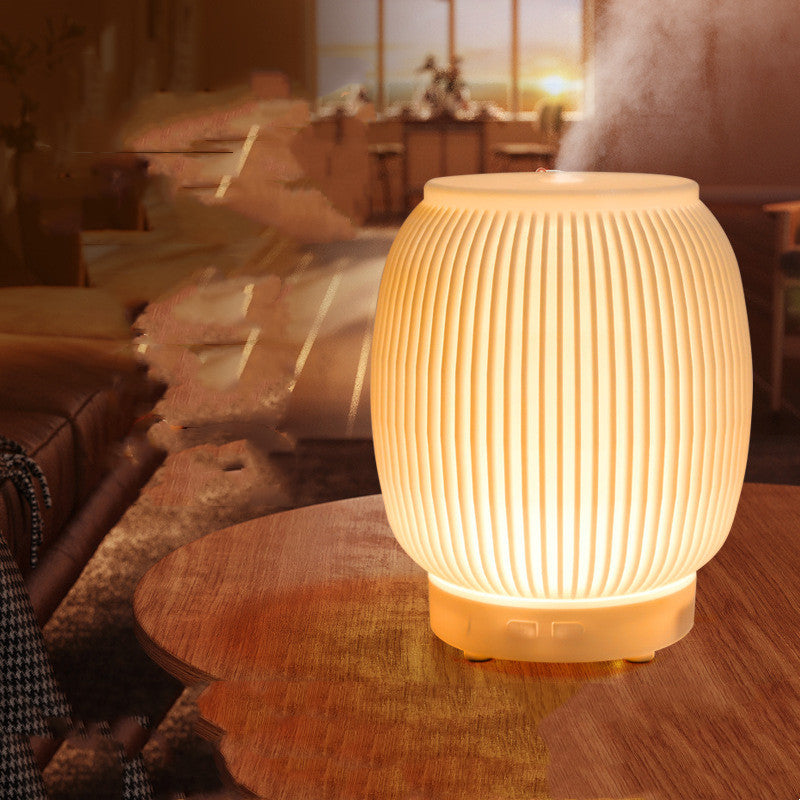 Sheila Merchandise automatic essential oil diffuser with warm light on wooden table emitting mist in cozy living room