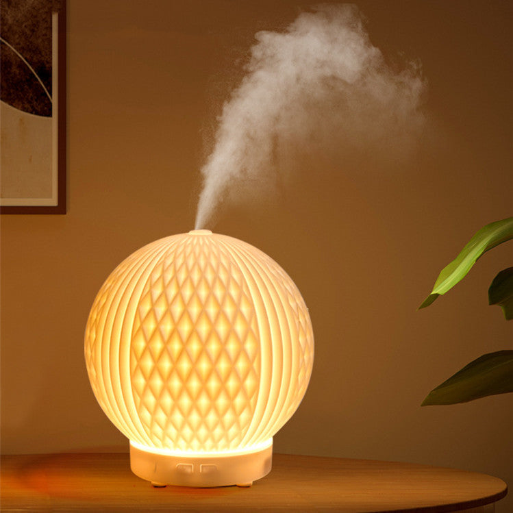 Sheila Merchandise automatic essential oil diffuser glowing with mist on wooden table in warm room