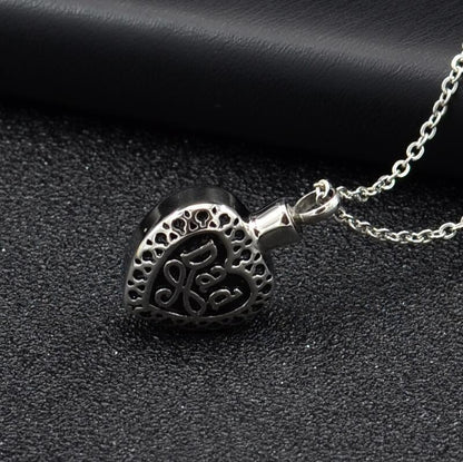 Silver heart urn pendant for ashes with intricate filigree design on a delicate chain