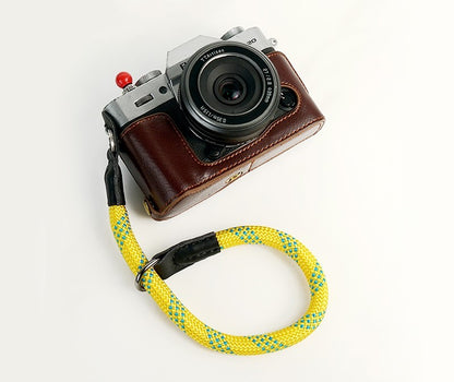 Durable camera wrist strap in yellow and blue attached to silver and brown vintage camera