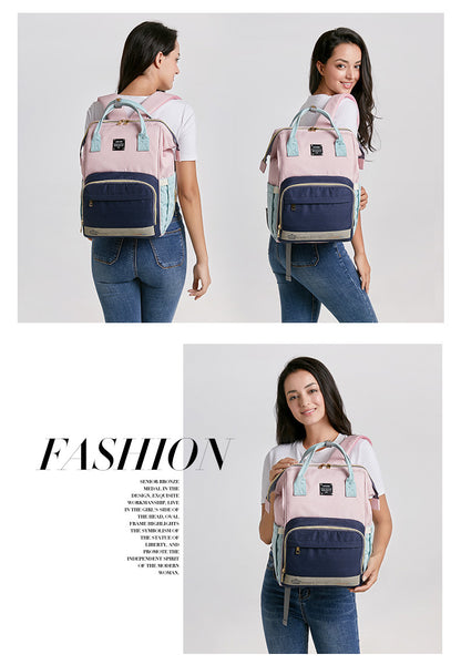 Sheila Merchandise pink and navy parent-approved diaper backpack worn by woman displaying spacious design