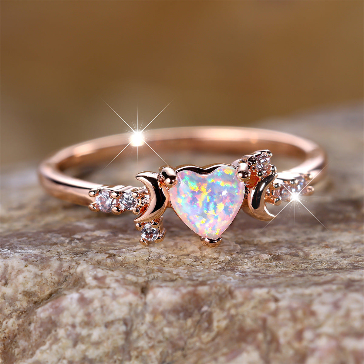 Rose gold moonstone love ring with heart-shaped center stone and three claw design on both sides