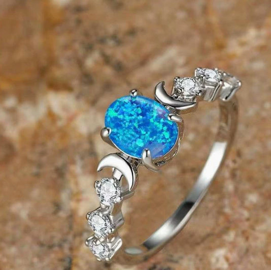 Sheila Merchandise moonstone love ring featuring a vibrant blue stone with silver claws and sparkling accents